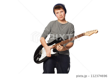 Teenager boy, guitar and studio portrait for rock music, performance or concert by white background. Creative person, artist kid or child musician with instrument for art, song or band with fashion 112374696