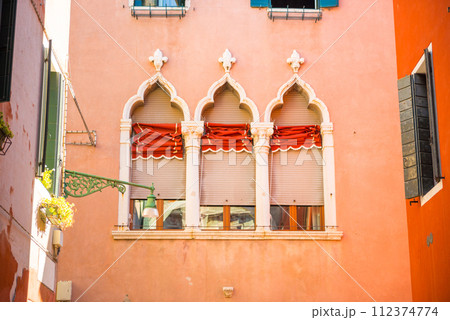 Windows on red wall in old house 112374774