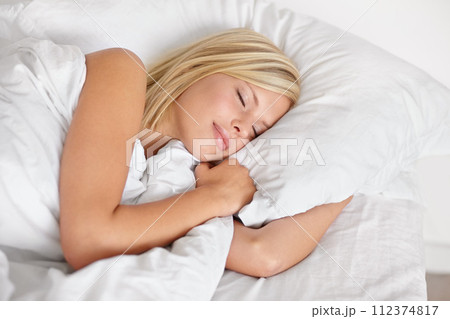 Woman, bed and sleeping with face, relax and dreaming in bedroom, resting and Apartment in morning. Tired, blanket and eyes closed on pillow, young female asleep in house on weekend with fatigue 112374817