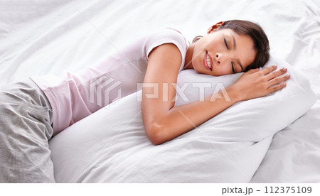 Sleep, pillow and woman relax in bedroom for comfort, cozy nap and rest with eyes closed in home apartment. Exhausted, fatigue and Mexican person sleeping on mattress bed for burnout, tired or dream 112375109