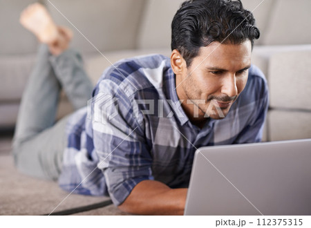 Man, freelancer and internet for laptop on floor of living room, research and scroll or browse on website. Male person, happy and online for information or home for app, remote work and plan on tech Man, freelancer and internet for laptop on floor of living room, research and scroll or browse on website. Male person, happy and online for information or home for app, remote work and plan on tech 112375315