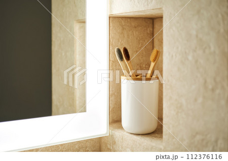 Natural bamboo toothbrushes in a glass in the bathroom. 112376116
