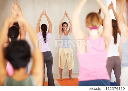 Stretching, yoga and group with personal trainer in class for fitness, exercise and workout on mat. Pilates, club and happy instructor with men and women for wellness, balance and healthy body Stretching, yoga and group with personal trainer in class for fitness, exercise and workout on mat. Pilates, club and happy instructor with men and women for wellness, balance and healthy body 112376160