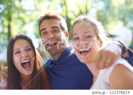 Portrait, friends and excited at music festival in nature, bonding and celebration with social fun in forest. Man, women and happy face in hug for care, camping and outdoor adventure in denmark woods 112376614