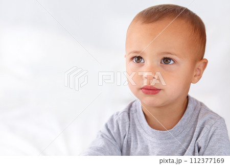 Thinking, cute and boy baby on bed in the nursery of modern home relaxing and sitting. Calm, mockup and serious young kid, infant or toddler with child development for growth in bedroom at house. 112377169