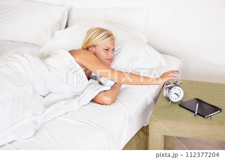 Snooze, alarm and woman wake up with clock in morning and tired on bed in home with stress, fatigue and lazy. Angry, girl and press stop or time to start day and frustrated with routine in bedroom Snooze, alarm and woman wake up with clock in morning and tired on bed in home with stress, fatigue and lazy. Angry, girl and press stop or time to start day and frustrated with routine in bedroom 112377204