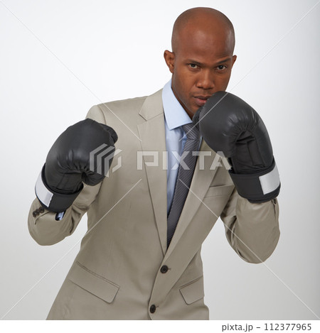 Businessman, portrait and boxing gloves for competition or corporate opportunity, rival or victory. Black man, face and confidence to fight for promotion in studio white background, career or mockup Businessman, portrait and boxing gloves for competition or corporate opportunity, rival or victory. Black man, face and confidence to fight for promotion in studio white background, career or mockup 112377965