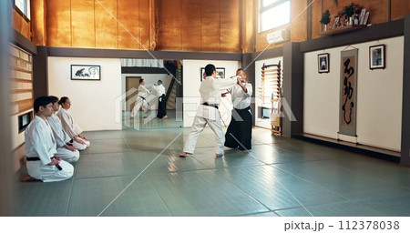 Aikido, sensei and Japanese students with training, fitness and action in class for defence or technique. Martial arts, people or fighting with discipline, uniform or confidence for culture and skill Aikido, sensei and Japanese students with training, fitness and action in class for defence or technique. Martial arts, people or fighting with discipline, uniform or confidence for culture and skill 112378038