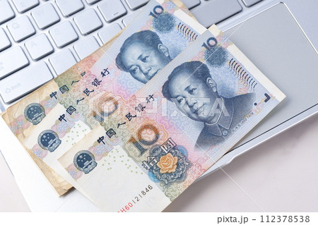 毛沢東の肖像が描かれた中国の通貨、人民元（RMB）の紙幣とノートパソコン 112378538