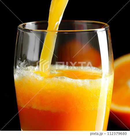 グラスに注がれる搾りたてのフレッシュオレンジジュース 112379680