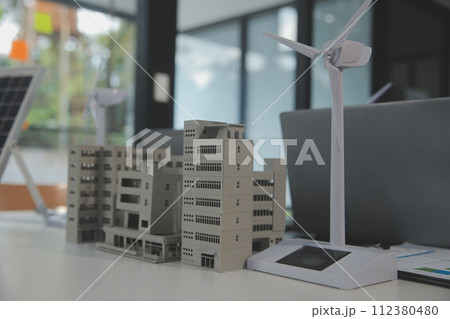 Close-up at tablet, Engineers pointing at tablet with their hands. To jointly design the use of renewable energy with wind and solar energy. Concept of using renewable energy. 112380480