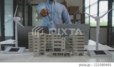 Close-up at tablet, Engineers pointing at tablet with their hands. To jointly design the use of renewable energy with wind and solar energy. Concept of using renewable energy. 112380493