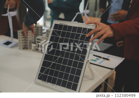 Close-up at tablet, Engineers pointing at tablet with their hands. To jointly design the use of renewable energy with wind and solar energy. Concept of using renewable energy. 112380499