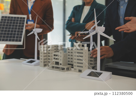 Close-up at tablet, Engineers pointing at tablet with their hands. To jointly design the use of renewable energy with wind and solar energy. Concept of using renewable energy. 112380500