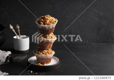 Tasty sweet baked muffins stacked on top of each other on black background 112380973