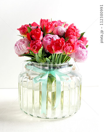Beautiful pink peony flowers bouquet in glass vase on white background 112380991