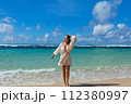 Beautiful young woman is happy by the sea 112380997