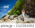 Beautiful young woman is happy on the beach of Bali 112381002