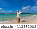 Young woman walks barefoot on the beach 112381008