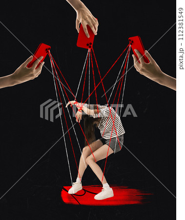 Contemporary art collage. Strings protruding from mobile cameras control depressed girl like puppet against black background. 112381549