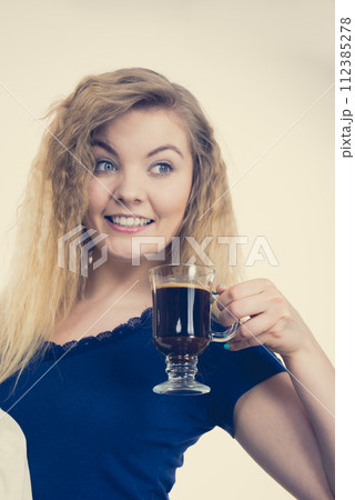Positive woman drinking her morning coffee Positive woman drinking her morning coffee 112385278