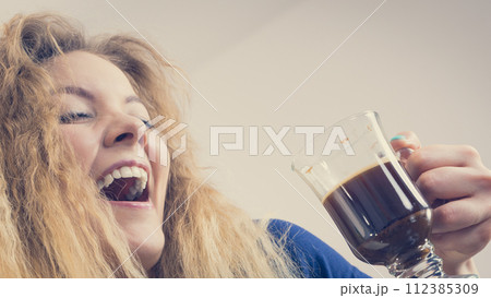 Positive woman drinking her morning coffee Positive woman drinking her morning coffee 112385309