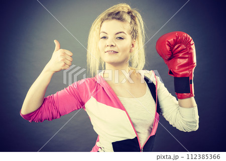 Woman wearing boxing gloves showing thumb up Woman wearing boxing gloves showing thumb up 112385366