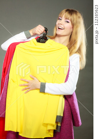 woman customer holding hangers with clothes 112385623