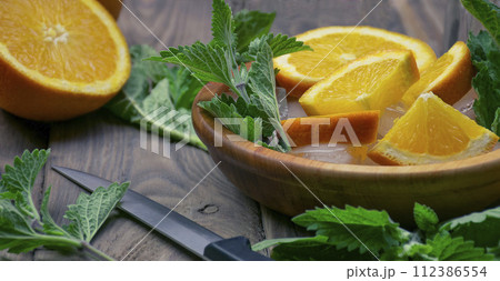 orange lemonade with soda water and mint, space for text. Fresh summer cocktail. 112386554