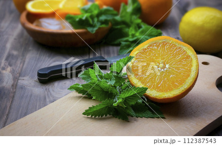 composition with fresh orange , mint, lemons  closeup. Fresh natural drink and fruits. 112387543