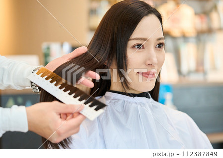 ヘアカラーチャートを当てる美容師 112387849