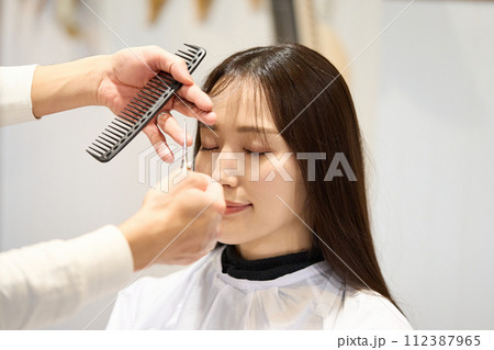前髪をカットする女性 112387965