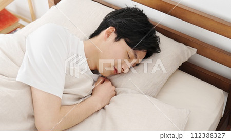寝返りを打つアジア人男性 寝返りを打つアジア人男性 112388327