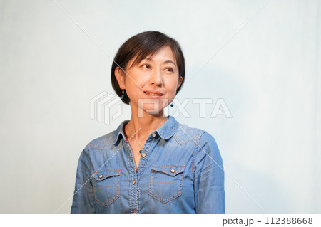 カジュアルシャツにペンダントとピアスをする女性 カジュアルシャツにペンダントとピアスをする女性 112388668