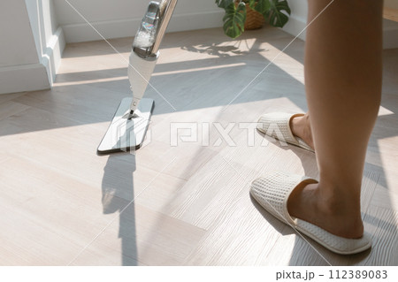 Close up angle of person feet and mop head, mopping and cleaning the floor of the house. Close up angle of person feet and mop head, mopping and cleaning the floor of the house. 112389083