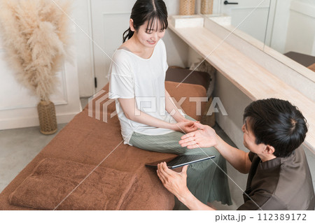 整体院・整骨院・マッサージのカウンセリングを受ける女性と整体師・セラピスト(タブレットPC) 整体院・整骨院・マッサージのカウンセリングを受ける女性と整体師・セラピスト(タブレットPC) 112389172