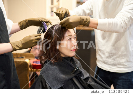 ヘアサロンで白髪染めをする女性客 112389423