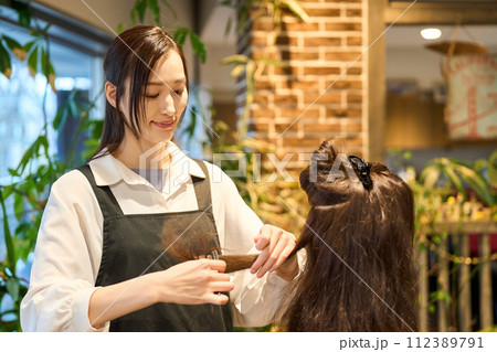 カットの練習をする美容師 112389791