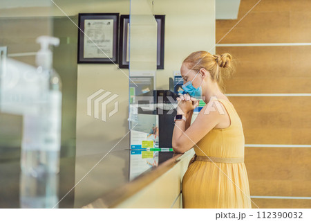 A pregnant woman stands at the hospital reception desk, embarking on a crucial phase of her maternity journey, seeking care and support in a healthcare setting A pregnant woman stands at the hospital reception desk, embarking on a crucial phase of her maternity journey, seeking care and support in a healthcare setting 112390032