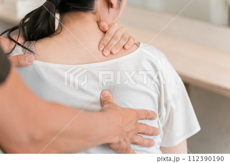 整体院・整骨院・マッサージに通う女性と整体師・セラピスト 112390190