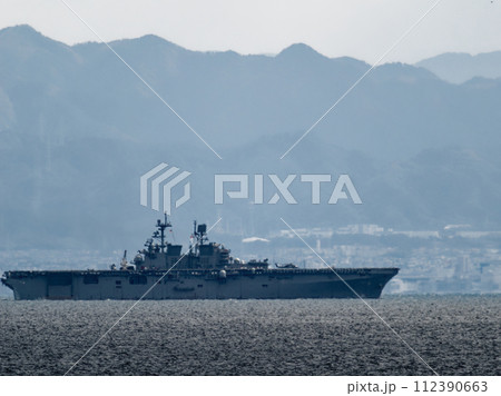 湾内から出向していくヘリコプターを搭載した軍用艦 112390663