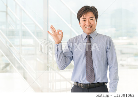 オフィスビルにいる中年のアジア人男性ビジネスマン（グッド・OK・ナイス・いいね） 112391062