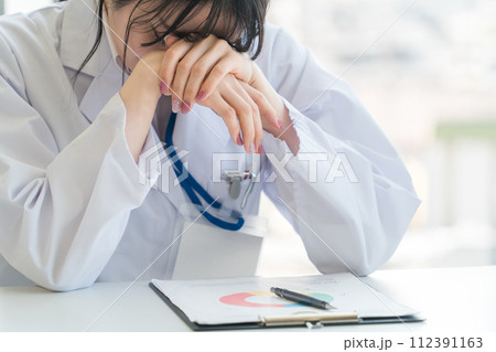 悩む女性医師・医者(疲れ・過労・プレッシャー・医師不足・不安・落ち込む・医療ミス・激務) 悩む女性医師・医者(疲れ・過労・プレッシャー・医師不足・不安・落ち込む・医療ミス・激務) 112391163