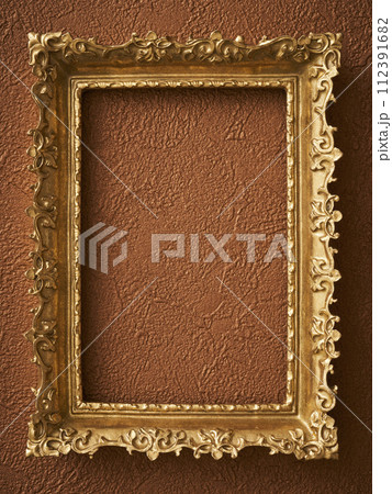 茶色い壁紙に掛けられたアンティークな額縁 112391682