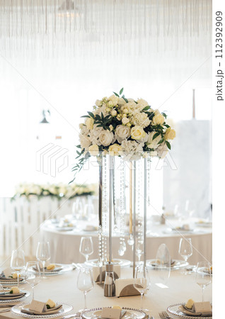 A beautiful vase of flowers on a table in a luxury restaurant. Wedding decorations A beautiful vase of flowers on a table in a luxury restaurant. Wedding decorations 112392909