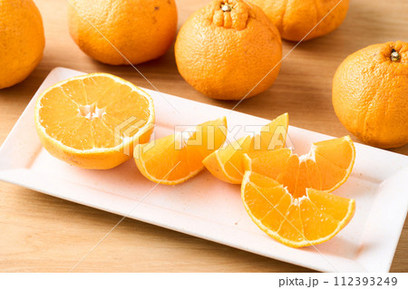 カットして盛り付けた、傷あり、不揃いのデコポン 112393249