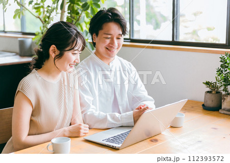 家でノートパソコンを見ながら話す夫婦・カップル(ネットショッピング・動画・検索) 家でノートパソコンを見ながら話す夫婦・カップル(ネットショッピング・動画・検索) 112393572