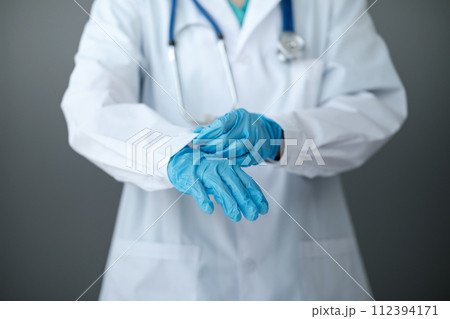 Doctor or nurse putting on sterile gloves. Close up concept. Virus. Testing covid 19. Ready for vaccination.  112394171