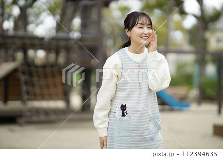 公園で園児を見守る保育士 公園で園児を見守る保育士 112394635