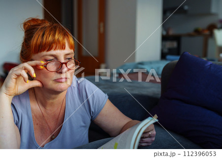 Portrait red-haired woman reading novel book Portrait red-haired woman reading novel book 112396053